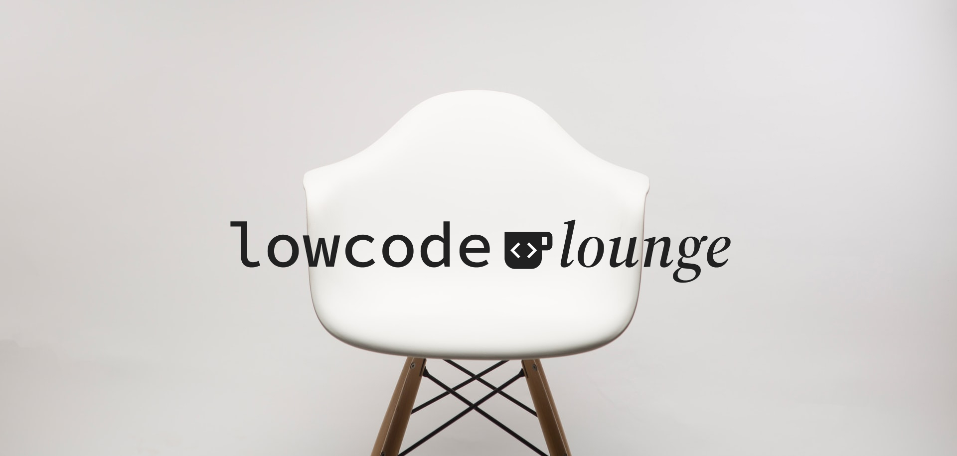 White, modern-style chair on a light grey background with the text lowcode lounge over it